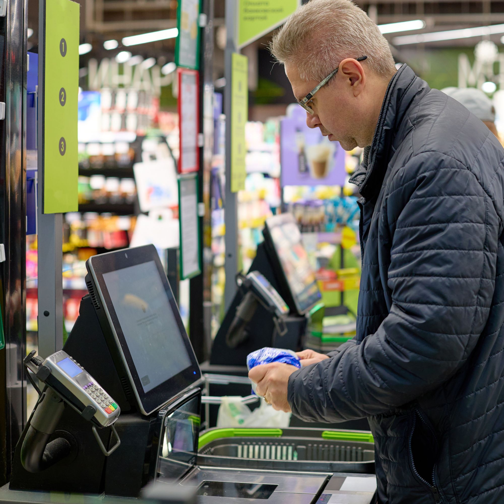 A woman using self service to pay for home goods.