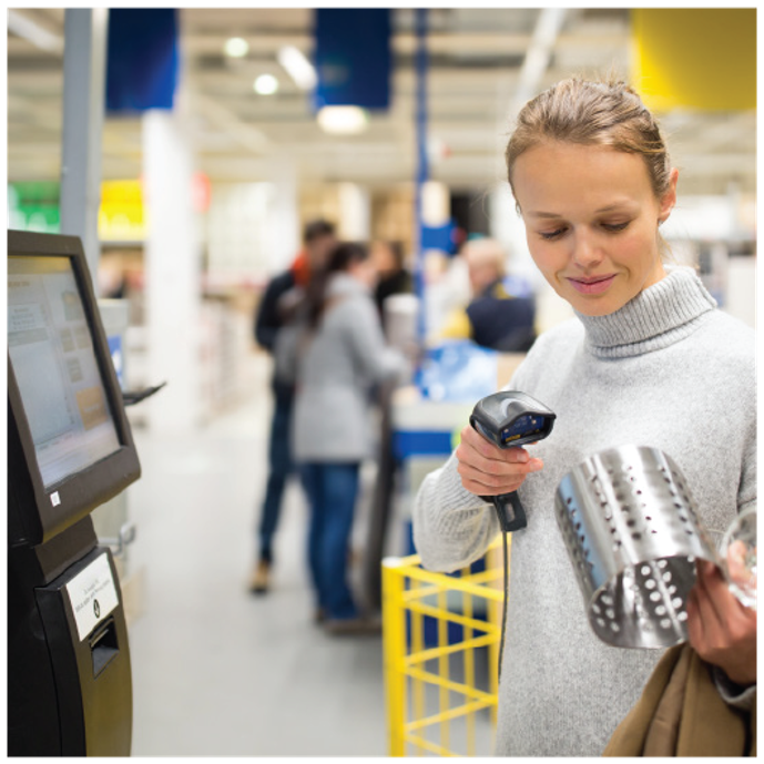 A woman using self service to pay for home goods.